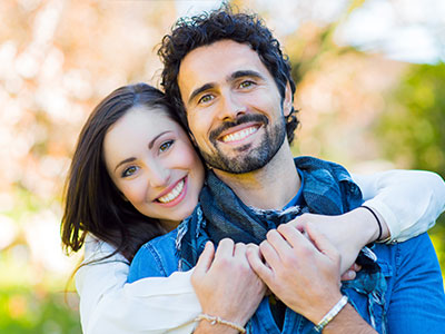 A man and woman embracing each other with smiles.