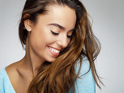 The image features a woman with long hair smiling at the camera.