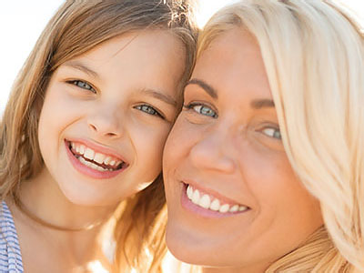 The image shows a woman and a child posing together with smiles, likely capturing a happy moment between them.